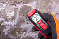 Digital moisture meter reading 26.9 percent on a bare concrete slab before epoxy coating