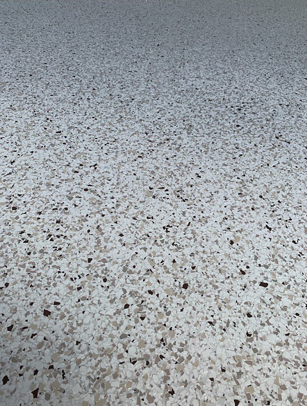 Close-up of a white, tan and brown epoxy flake floor