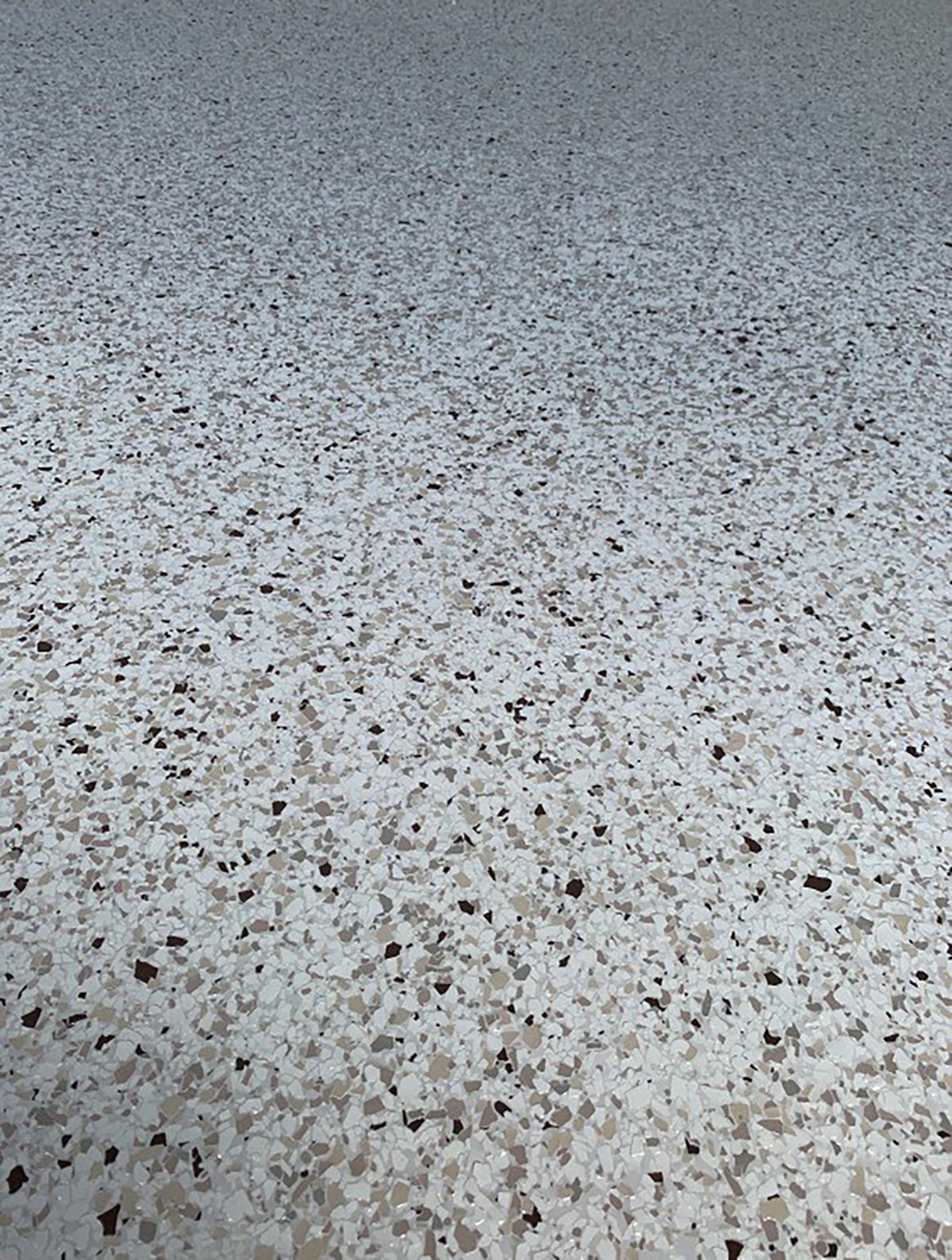 Close-up of a white, tan and brown epoxy flake floor