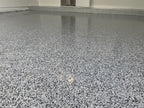 Black, white and grey epoxy flake garage floor with a glossy finish and matching flake cove base