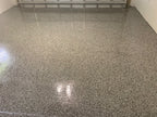 Grey epoxy flake garage floor sealed with a high-gloss polyaspartic clear topcoat